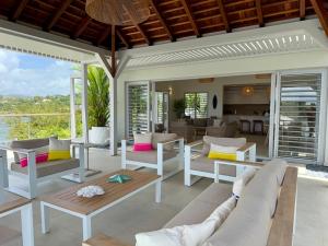 Una sala de estar con muebles blancos y vista al mar. en EAST KEYS - Villa One Love, piscine et accès privatif à la mer, en Le Vauclin 3 fotos más