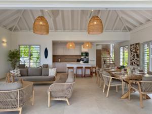 Una sala de estar con mesa y sillas y una cocina. en EAST KEYS - Villa One Love, piscine et accès privatif à la mer, en Le Vauclin