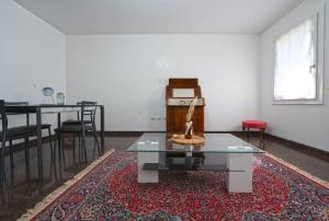 sala de estar con mesa y alfombra roja en Sybilvilla, en Oriago Di Mira