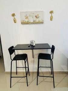 a black table with two chairs in a room at Plataview Apartahotel apt 3C in Monte Plata +19 photos