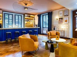 サン・ジェルヴェ・レ・バンにあるLe Saint Gervais Hotel & Spa Handwritten Collectionの部屋の中に黄色い椅子とテーブルがあるバー +68枚の写真