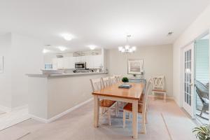 a kitchen and dining room with a wooden table and chairs at Sea Colony - 56216 Pine Branch Way in Bethany Beach