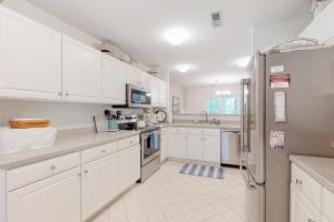 a white kitchen with white cabinets and a refrigerator at Sea Colony - 56216 Pine Branch Way in Bethany Beach +43 photos