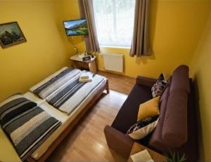 a living room with a bed and a couch at Penzion & Restaurace Kozabar in Luby