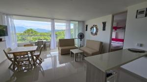 a kitchen and living room with a table and chairs at Relájate y Disfruta, Apartamento con Piscina, Tobogán y Vista Espectacular en Santa Fé de Antioquia in Santa Fe de Antioquia