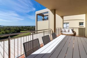 BRAND NEW Luxury Apartment with Ocean View في بليتنبيرغ باي: شرفة منزل مع أريكة وكراسي