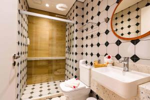 ein Badezimmer mit Waschbecken, Toilette und Spiegel in der Unterkunft Santé Vivre L'Experience by Livá OFICIAL in Búzios