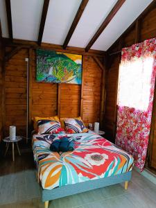 Un dormitorio con una cama en una habitación de madera. en Bungalow Catalpa, en Anse-Bertrand