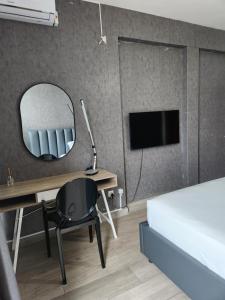 a bedroom with a bed and a desk with a mirror at Premium Suites in Maputo