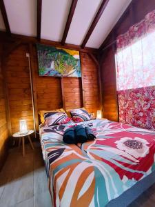 a bedroom with a large bed in a room at Gites kaz à klemence - Bungalow karapat - jacuzzi privé et piscine partagée au cœur de la nature à Anse-Bertrand in Anse-Bertrand
