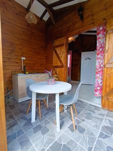 a kitchen with a table and chairs in a room at Gites kaz à klemence - Bungalow karapat - jacuzzi privé et piscine partagée au cœur de la nature à Anse-Bertrand in Anse-Bertrand
