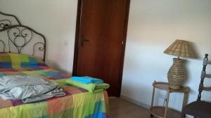ein Schlafzimmer mit einem Bett und einer Lampe auf einem Tisch in der Unterkunft Attici Centrali in Sabaudia
