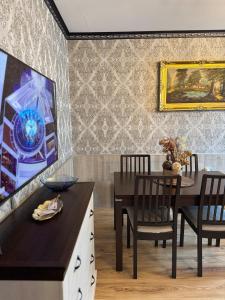 a dining room with a table and chairs and a painting at Pirin Elegance Apartment by Gondola Lift in Bansko