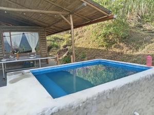 a swimming pool in a backyard with a table next to it at Posada Rural Aguita de Panela in La Vega +13 photos