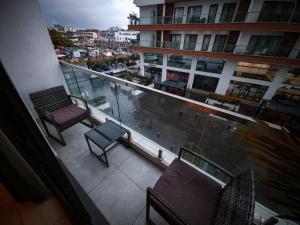 a balcony with two chairs and a view of a city at Premium Studio Apartment, East Legon in Accra