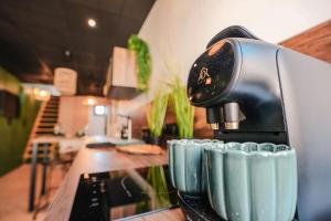 a coffee maker sitting on a counter next to cups at L'Amazone - Jungle Room avec Jacuzzi in Pont-du-Château