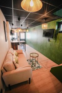 a living room with a couch and a table at L'Amazone - Jungle Room avec Jacuzzi in Pont-du-Château