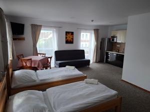 a hotel room with two beds and a table at Parťákova Hasičárna & Penzion in Hradec Králové