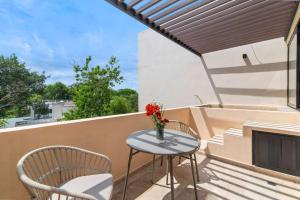 a table and chairs on a balcony with a fireplace at Stylish 1BR Condo with Private Pool & Balcony in Tulum