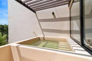 a hot tub on the balcony of a house at Stylish 1BR Condo with Private Pool & Balcony in Tulum