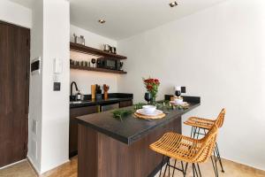 a kitchen with a counter and two chairs at Stylish 1BR Condo with Private Pool & Balcony in Tulum +34 photos