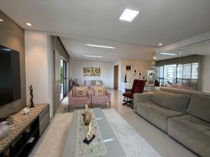 a living room with a couch and a tv at Apartamento COP30 de Alto Padrão in Belém