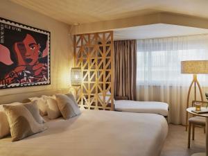 Una habitación de hotel con dos camas y un cuadro en la pared. en Mercure Saint Raphael Centre Plage, en Saint-Raphaël 4 fotos más