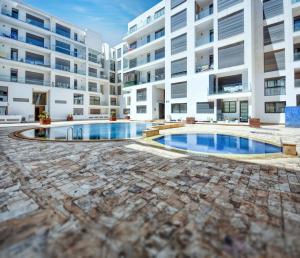 a swimming pool in the middle of a building at Serenity - Appart Piscine - 4-5p in Agadir