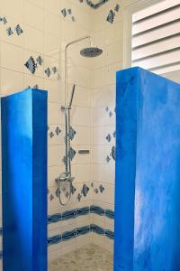 a bathroom with a shower with blue glass doors at FaraTea Bay house in Paopao +24 photos