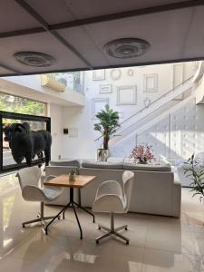 Una sala de estar con un sofá, una mesa y sillas. en Santa Limbania Boutique Hotel, en Santa Cruz de la Sierra
