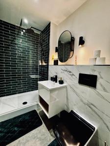 Baño blanco con lavabo y bañera en Royal Stay-Leeds City centre Apartment, en Central Station