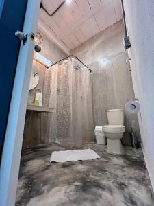 a bathroom with a shower and a toilet at Calma Hospedaje in Turbaco