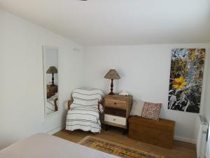 a bedroom with a bed and a chair and a dresser at Maison indépendante à la campagne proche centre urbain in Muret