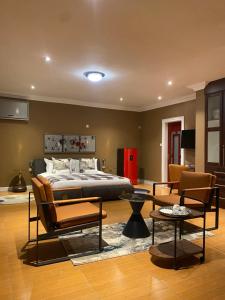 a bedroom with a bed and a living room at Stone Guesthouse in Gaborone