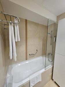 y baño con bañera blanca y ducha. en Secret love room, en Bucarest