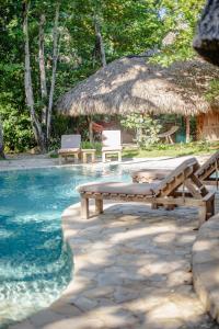 a pool with a table and chairs and a hut at Natura Cabana Boutique Hotel & SPA in Cabarete +64 photos