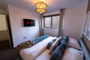 ein Schlafzimmer mit einem Bett mit Kissen darauf in der Unterkunft Spacious 3-Bed Home with Free Off-Street Parking Near Newcastle in East Howdon + 24 Fotos