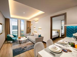 ハノイにあるMövenpick Living West Hanoiのソファとテーブルと椅子のあるリビングルーム
