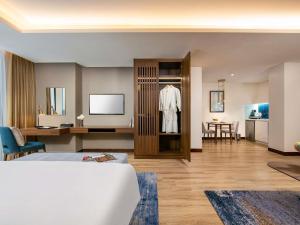 ハノイにあるMövenpick Living West Hanoiのベッドと机があるホテルの部屋