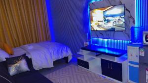 a bedroom with a bed and a tv in it at Tonystays, Tsavo in Nairobi