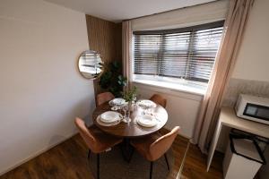 ein Esszimmer mit Tisch und Stühlen und einem Fenster in der Unterkunft Spacious 3-Bed Home with Free Off-Street Parking Near Newcastle in East Howdon
