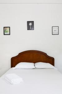 a bed with two pillows and three pictures on the wall at Hotel Villa Ivel in Turbaco