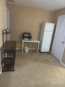 a kitchen with a refrigerator and a table with a microwave at Comfort Stays Relax in a Cozy King Bedroom in Justin