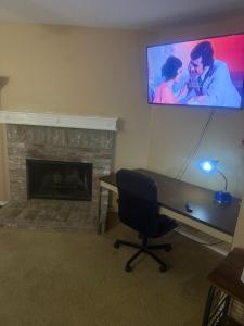 a room with a desk and a television on the wall at Comfort Stays Relax in a Cozy King Bedroom in Justin