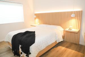 a bedroom with a bed with a black blanket on it at Hotel Colina Inn Escazu in San Rafael