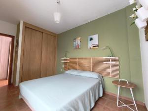 una camera da letto con un letto bianco e una sedia di Sun&Sand Cotillo a Cotillo Altre 11 foto