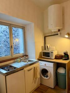 a small kitchen with a sink and a microwave at Le Petit Bohème - WiFi - Hyper-Centre in Bourges