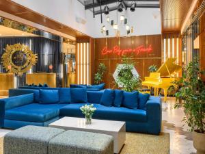 a living room with blue couches and a piano at Pullman Budapest in Budapest