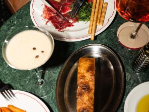 a table with plates of food and a slice of pizza at Pullman Budapest in Budapest
