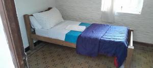 un piccolo letto in una camera con coperta blu di Atardecer en el Río a Colonia del Sacramento